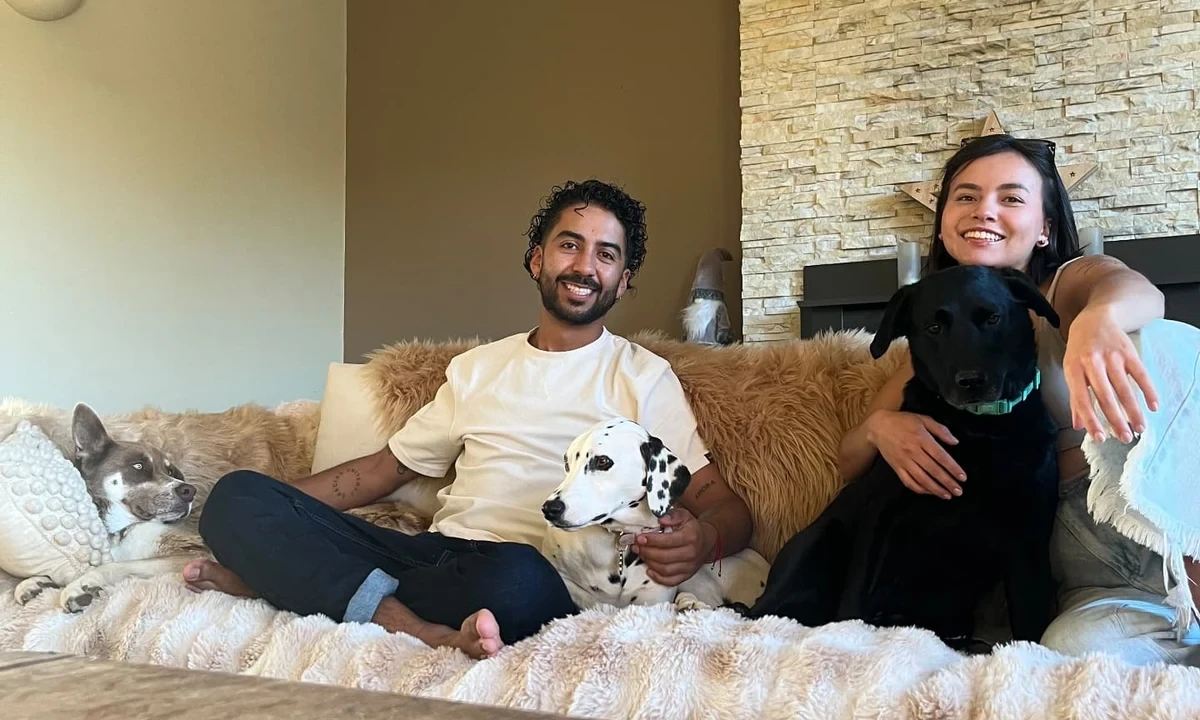 Yen and Nico relaxing on the sofa at home with three dogs